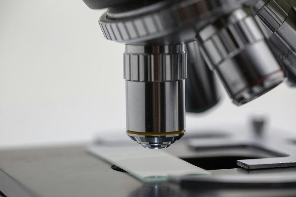 The objective lens of a microscope above a slide